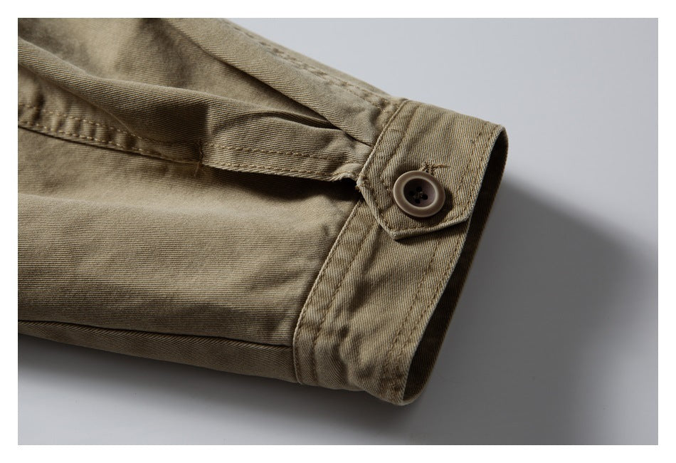 Close-up of a tan garment cuff with a button closure and visible stitching.