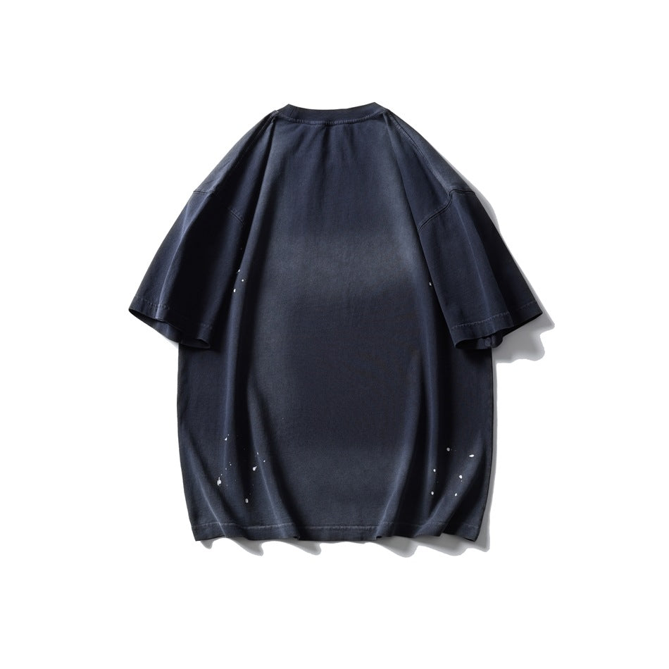 Back of an oversized dark navy short-sleeve T-shirt with small white paint-like splatters near the sides and hem.