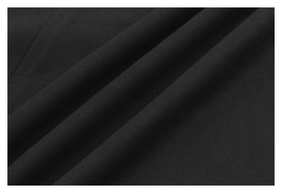 Close-up showing the black garment fabric arranged in soft folds.