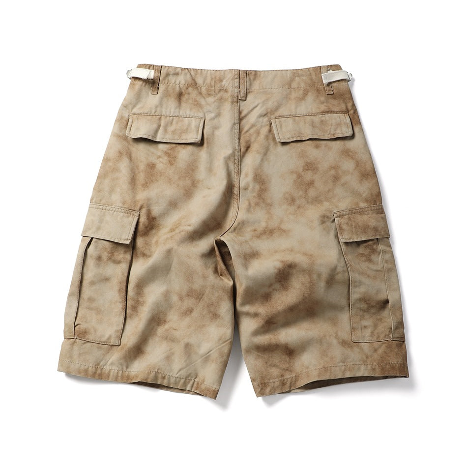 Full rear view of tan mottled cargo shorts with flap pockets and adjustable waist tabs.