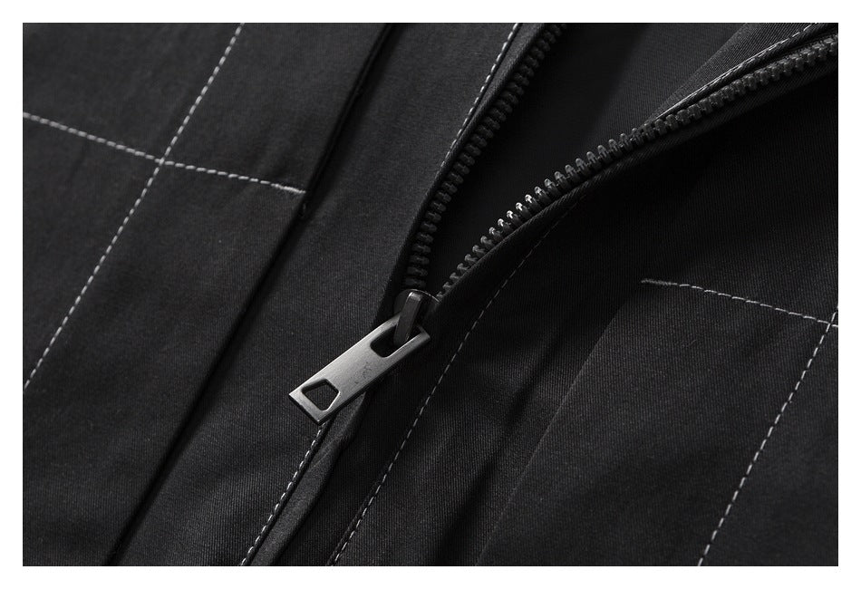 Close-up of a black garment zipper with a metal pull and contrast-stitched panels.