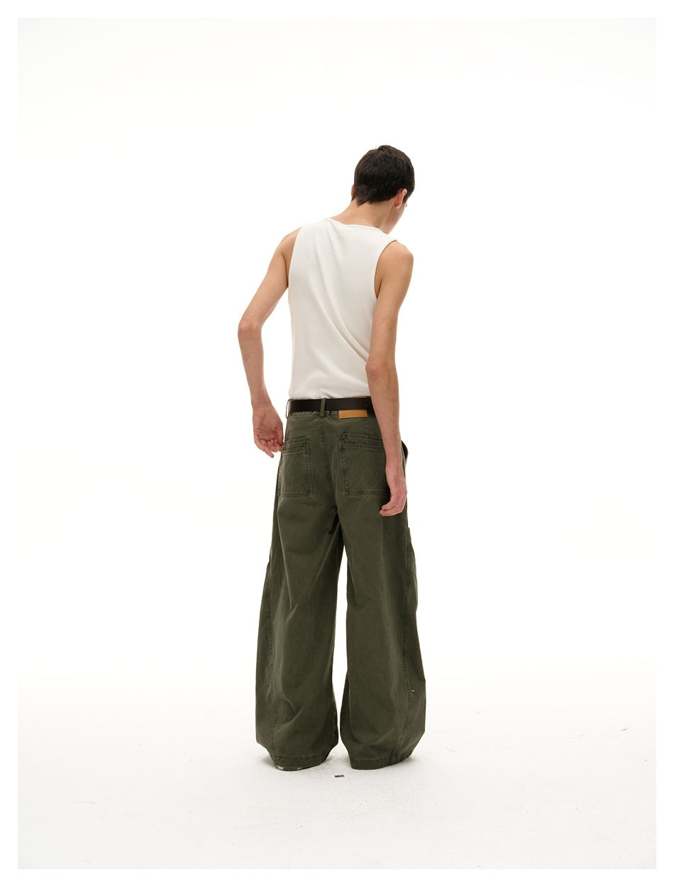 Back view of a model wearing dark olive wide-leg pants with two back pockets and a white tank top.