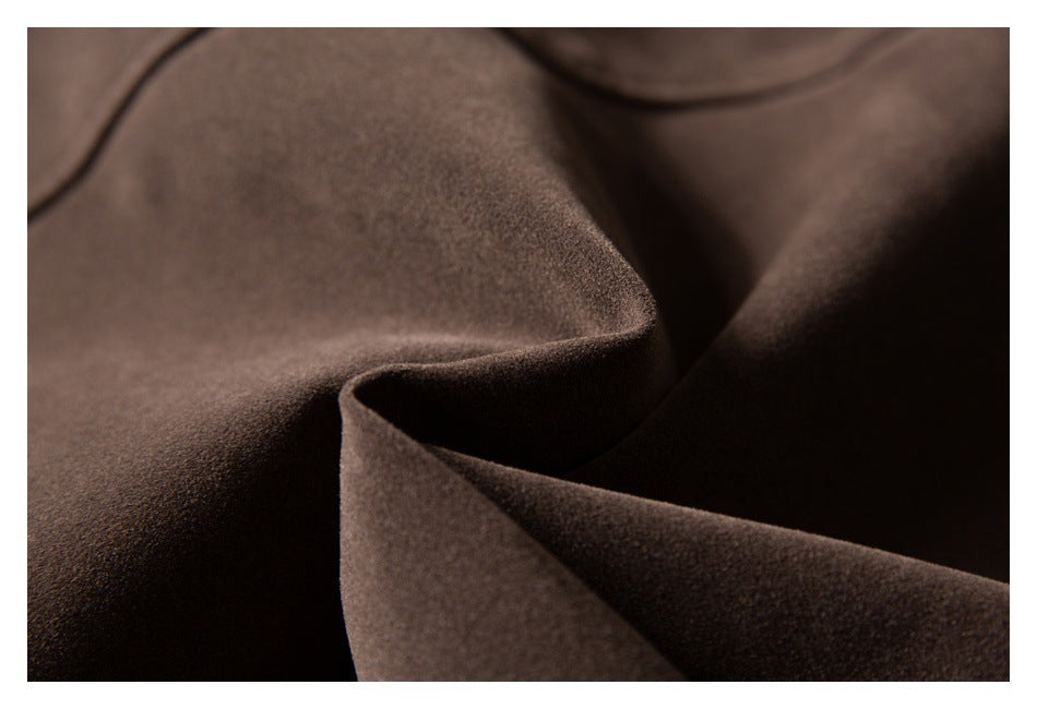 Close-up of the soft-looking surface and folds of dark brown garment fabric.