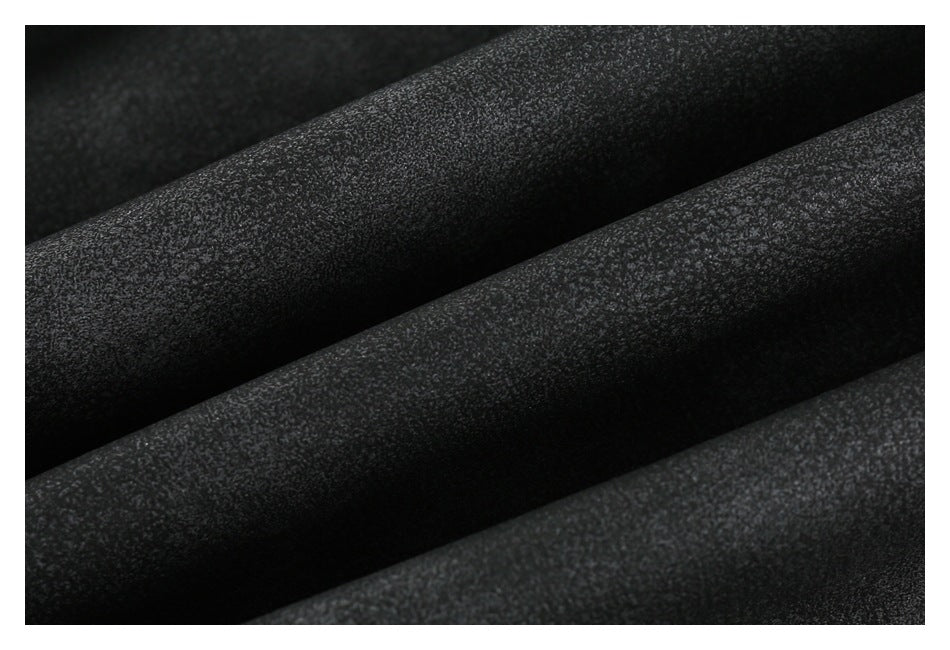Extreme close-up showing the subtly textured surface of black fabric in folds.