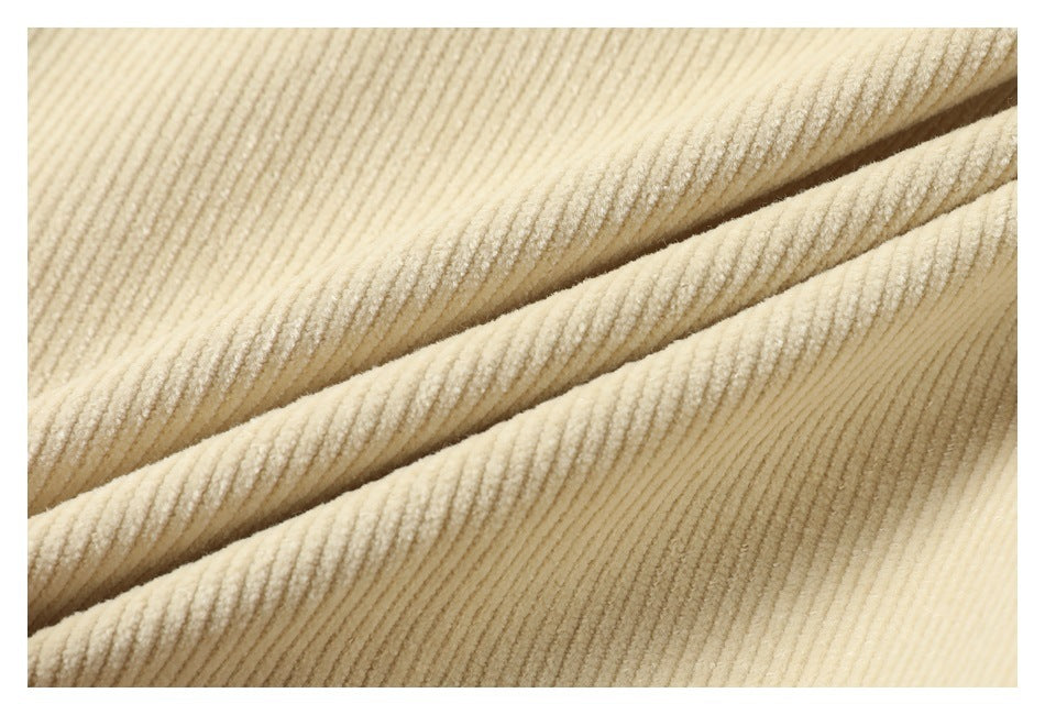 Close-up of cream-colored ribbed fabric folded into diagonal layers.