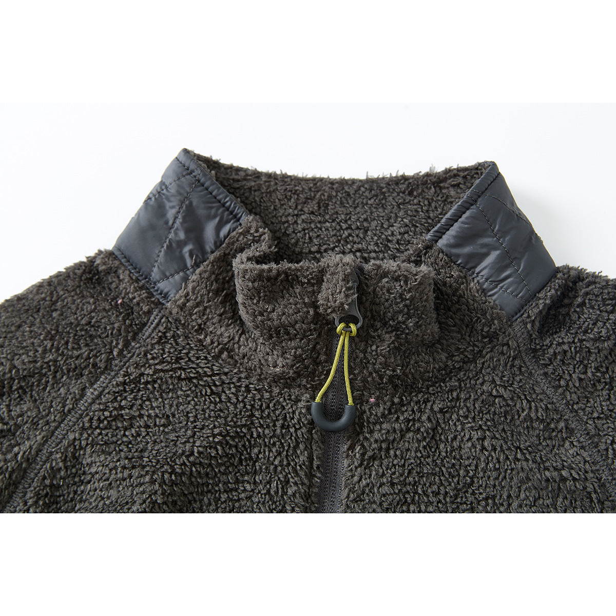 Close-up of a charcoal fleece pullover collar with black shoulder panels and a yellow zipper pull.