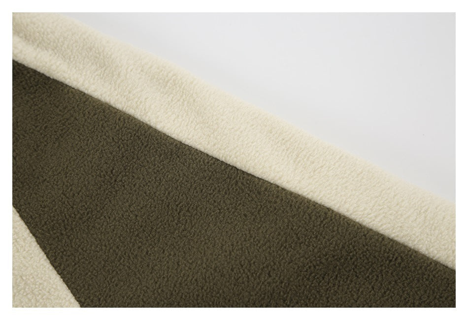 Close-up of cream and dark olive textured fleece panels on a jacket.