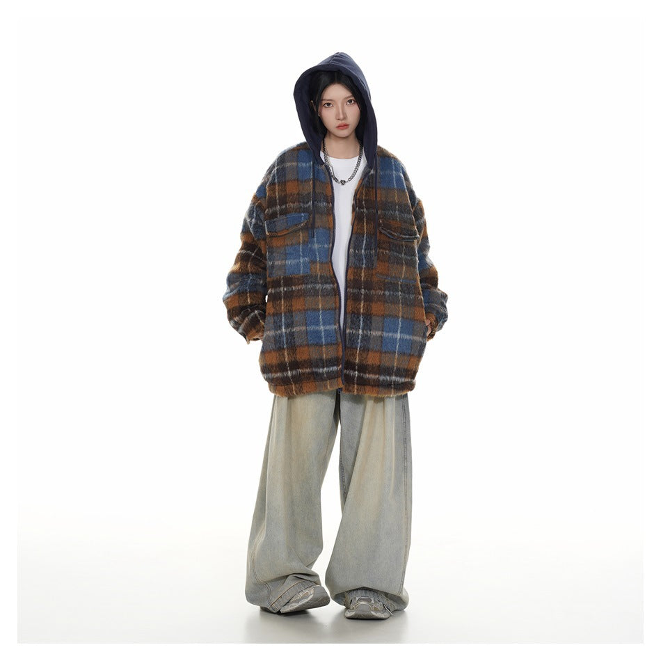 Full-length view of model in brown and blue plaid hooded jacket with hood up, white top and faded wide-leg jeans