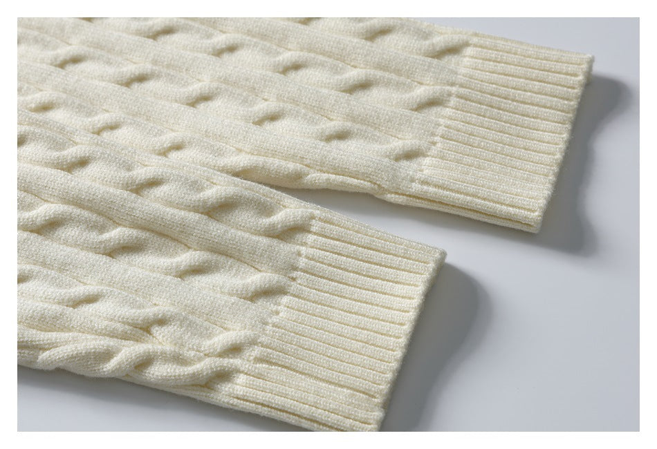 Close-up of two ivory cable-knit sleeves with wide ribbed cuffs.