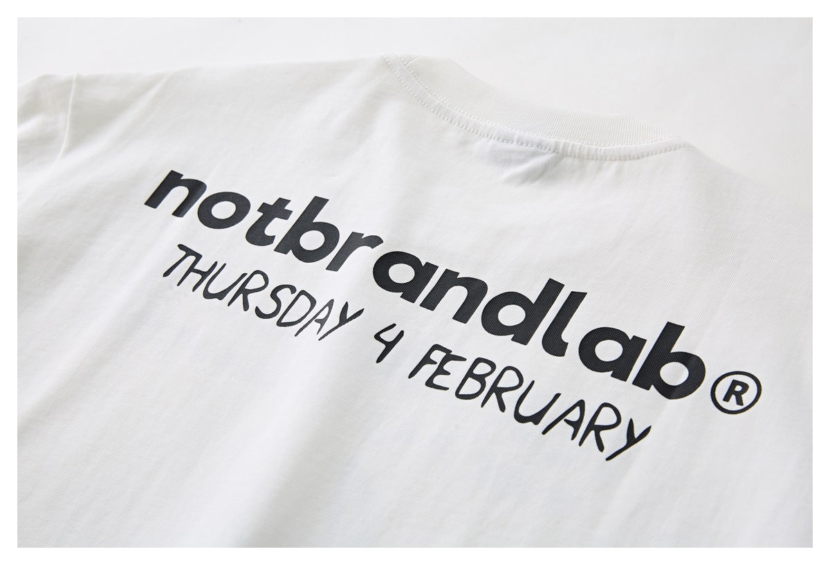 Close-up of the back of a white T-shirt with bold black lettering and a date printed across it.