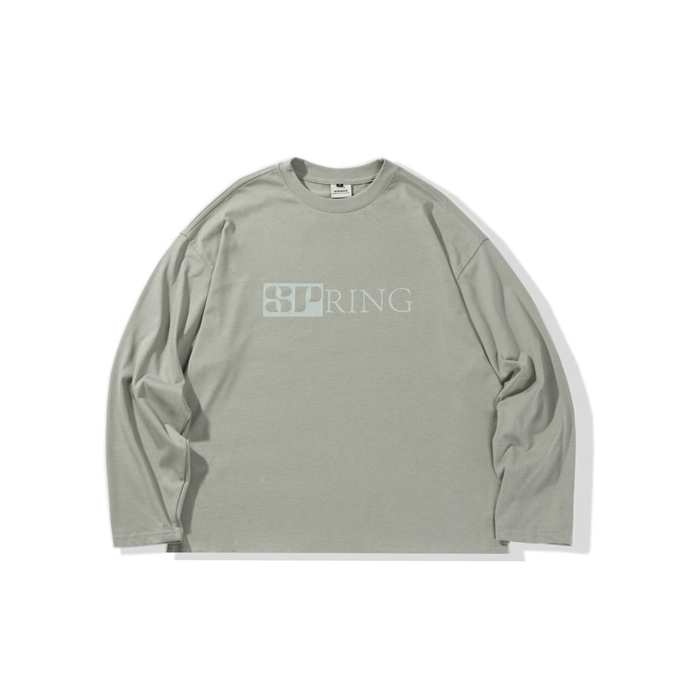 Gray-green long-sleeve crew-neck top with drop shoulders and a tonal SPRING graphic on the chest, flat lay