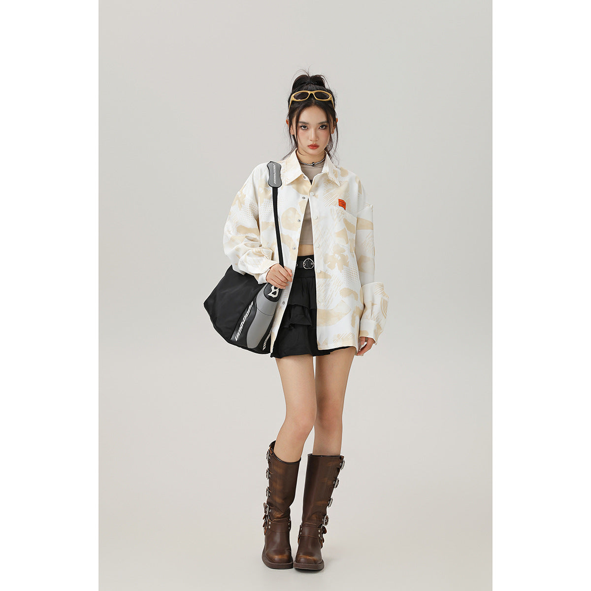 Model wearing an oversized cream button-up shirt with a beige abstract print, shown from the front.