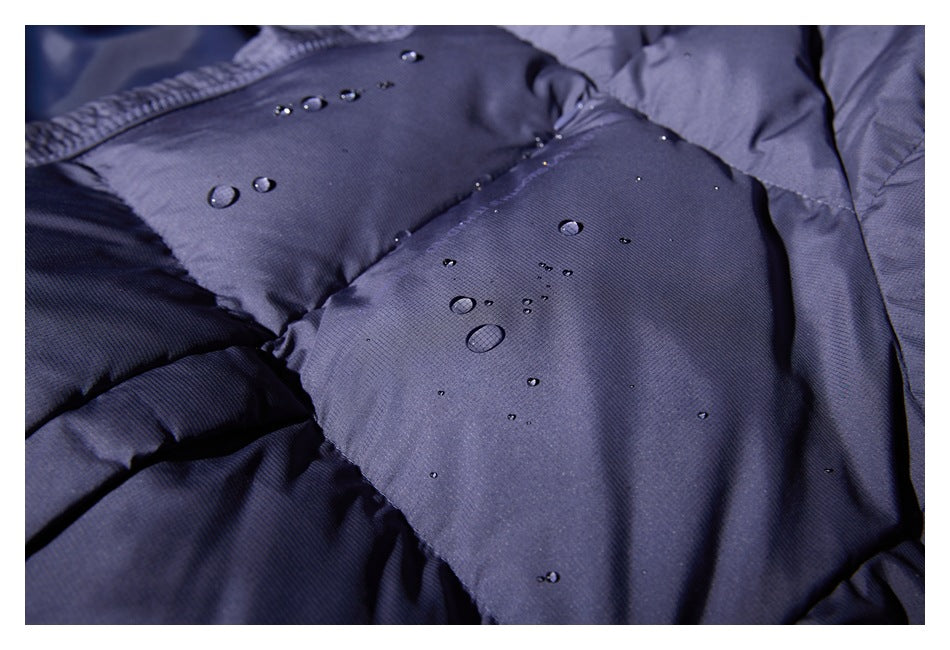 Close-up of a dark blue padded garment with water droplets beading on the surface.