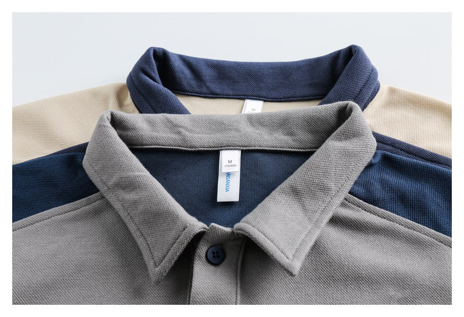 Close-up of layered gray and navy polo collars with cream and blue panels and visible neck labels.