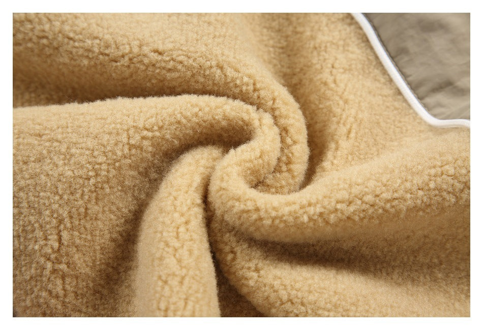 Close-up of tan plush fabric folded to show its soft-looking textured surface and white piping.