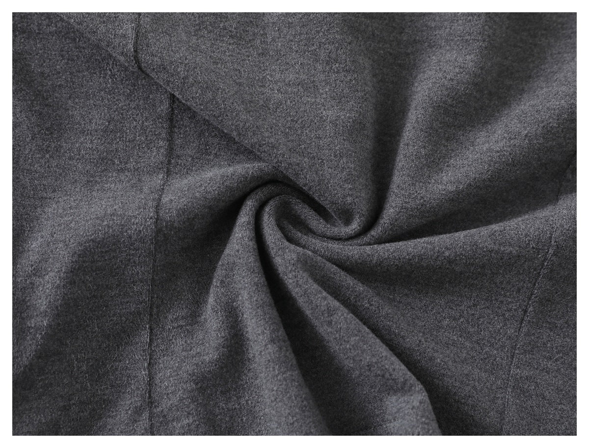 Close-up of charcoal gray fabric gathered into a soft spiral fold.