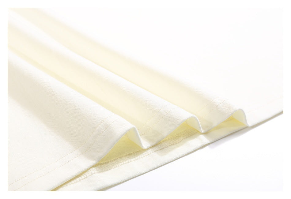 Close-up of the off-white T-shirt bottom hem and stitched edge.