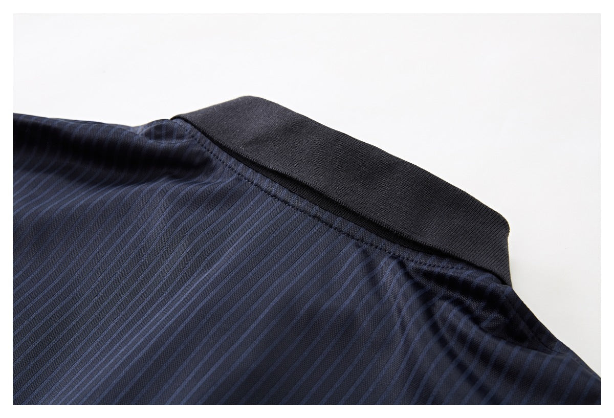 Close-up of the dark ribbed collar and shoulder seam on a dark navy pinstriped polo shirt.