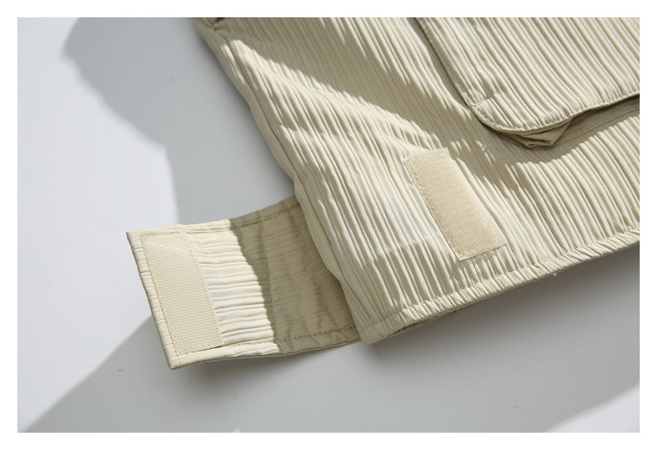 Close-up of an ivory ribbed jacket showing a hook-and-loop cuff adjustment tab.