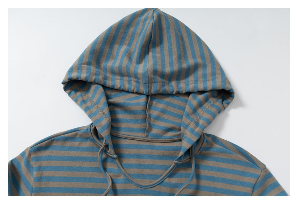 Close-up of the striped top's hood, seams, and drawstrings against a white background.