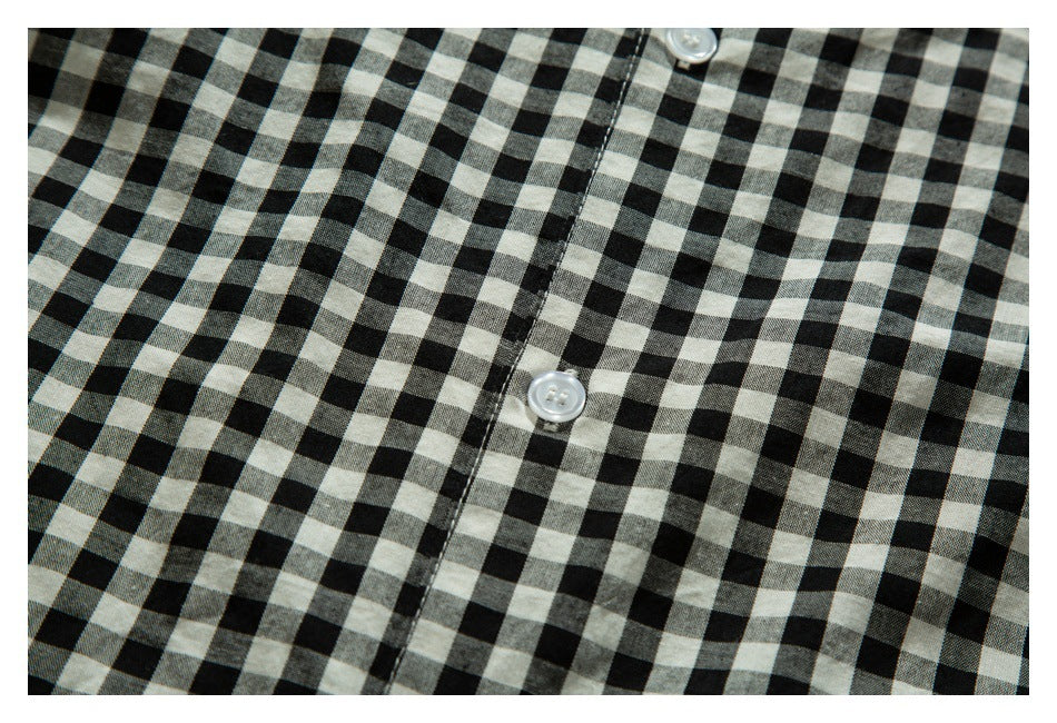 Close-up of a black-and-white gingham shirt showing the button placket and white buttons.