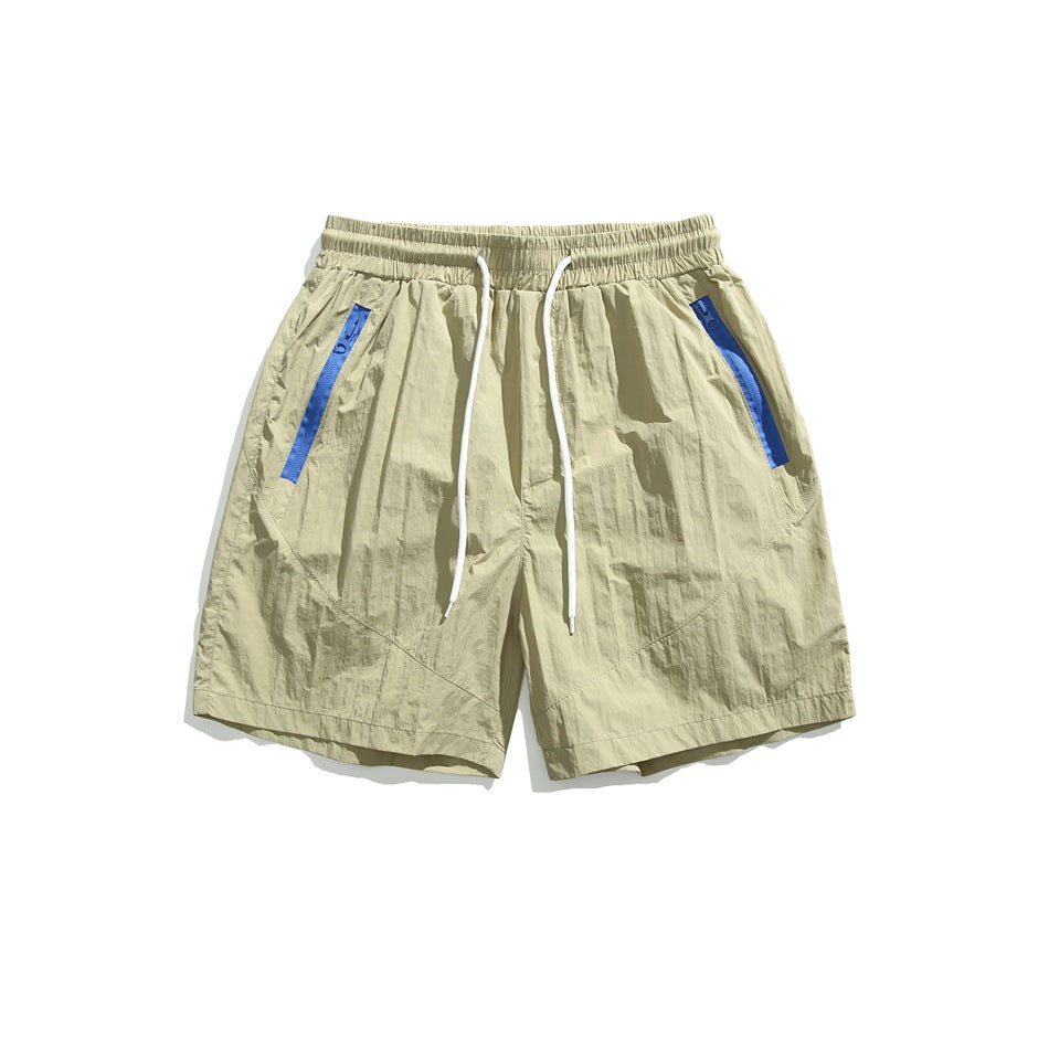 Khaki drawstring shorts with blue zipper-tape pockets, flat lay front view