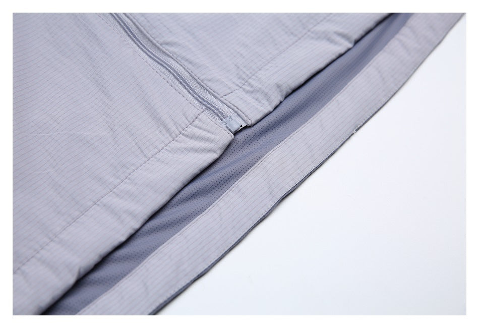 Close-up of the pale gray-lavender jacket's lower zipper and dark perforated inner hem panel.
