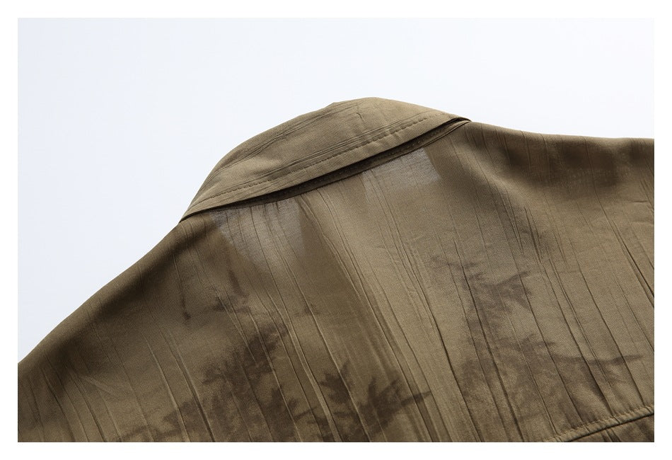 Close-up of the back collar and shoulder seam of a brown abstract-patterned shirt.