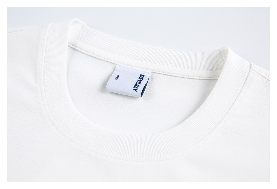 Close-up of a white T-shirt's ribbed crew neck, stitching, and sewn-in label.