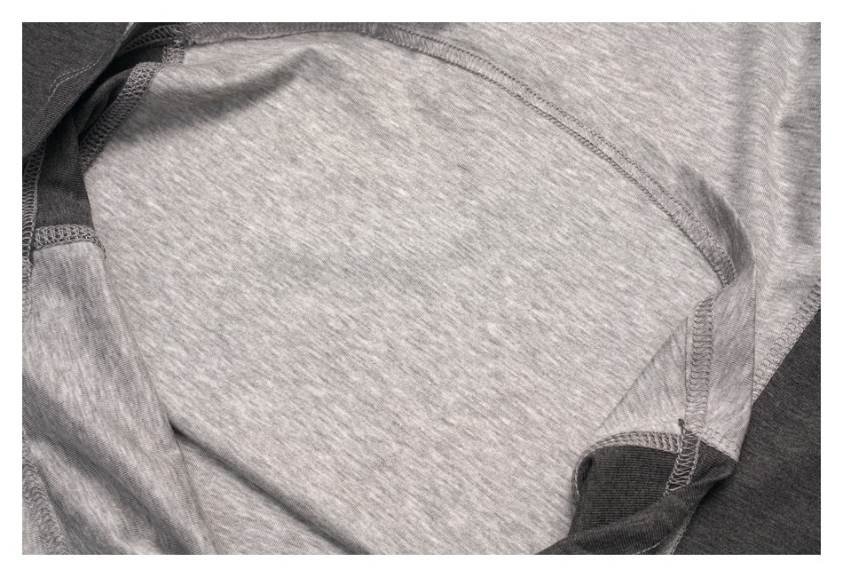 Close-up of a heather gray garment interior showing curved seams and dark fabric panels.