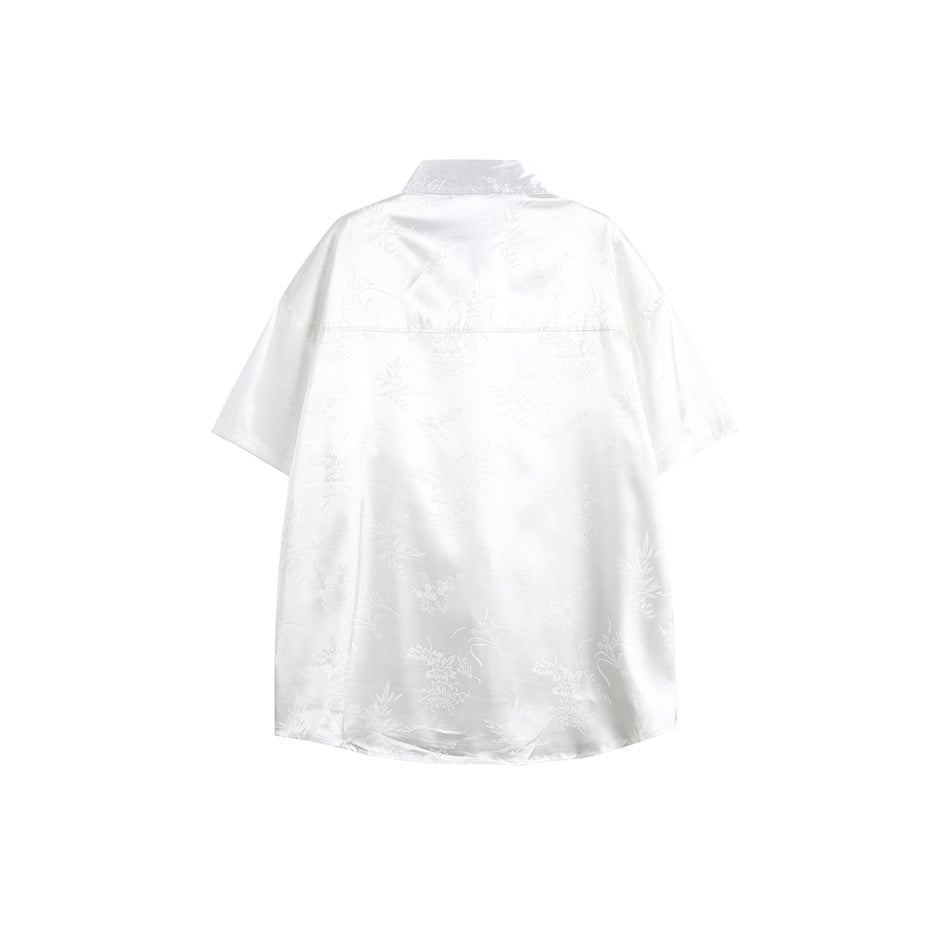 Back view of a white short-sleeve collared shirt with a subtle floral pattern.