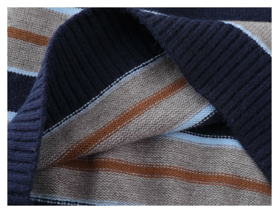 Close-up of folded navy ribbed knit edging beside gray fabric with rust and pale blue stripes.