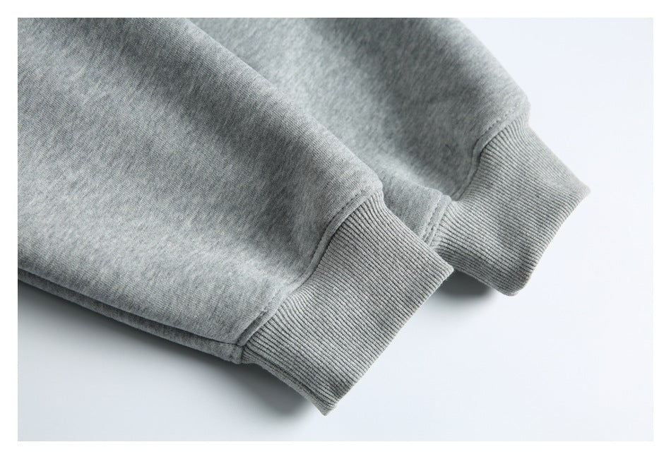 Close-up of two gray sweatshirt sleeves with ribbed cuffs and visible stitching.
