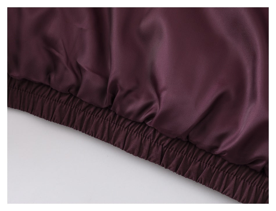 Close-up of a burgundy jacket's gathered elastic hem.