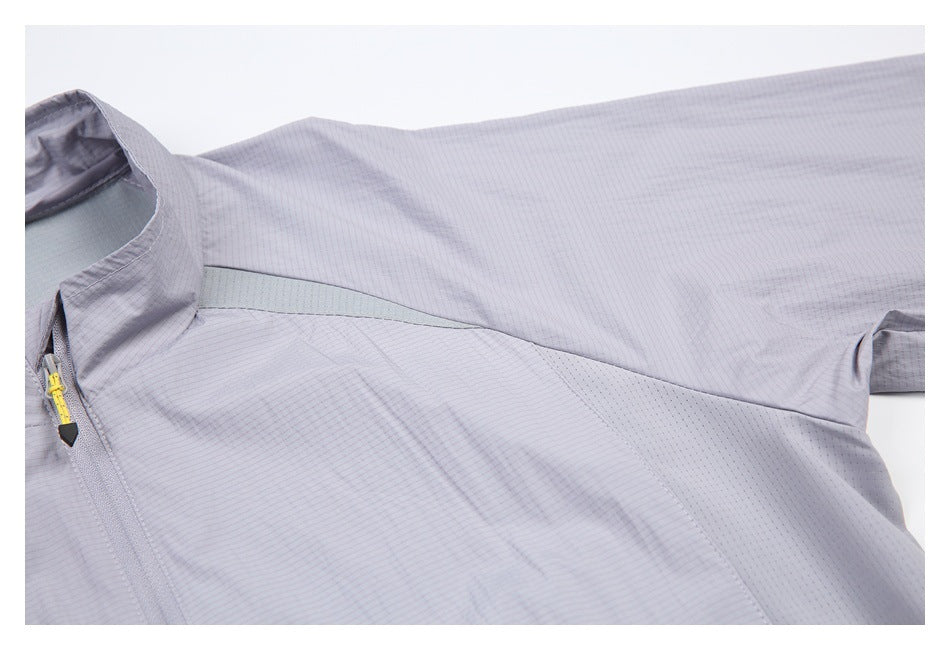 Close-up of the light gray jacket's stand collar, front zipper with yellow pull, and shoulder panel.
