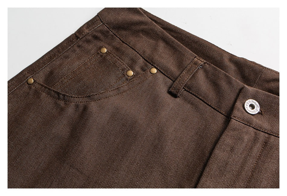 Close-up of dark brown trousers showing a front pocket, waistband, belt loop, and metal button.