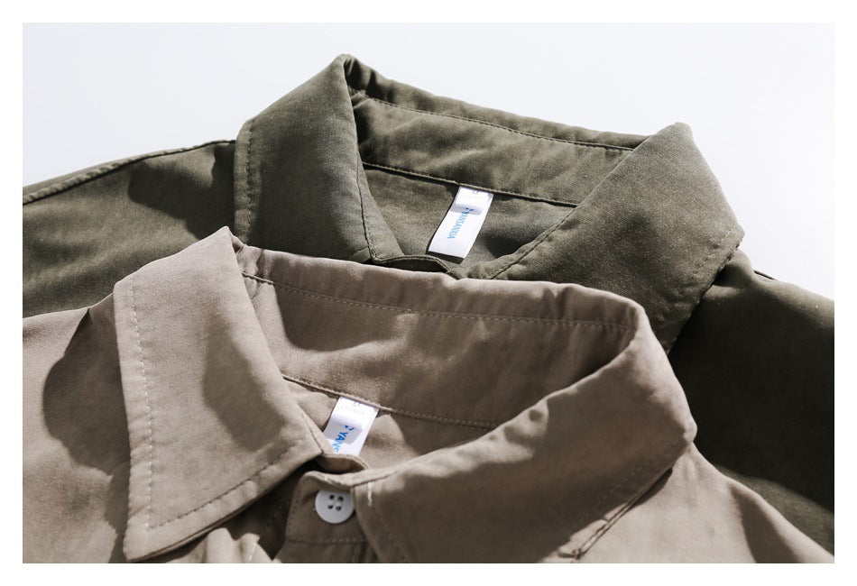 Close-up of overlapping taupe and olive button-up shirt collars with visible stitching and neck labels.