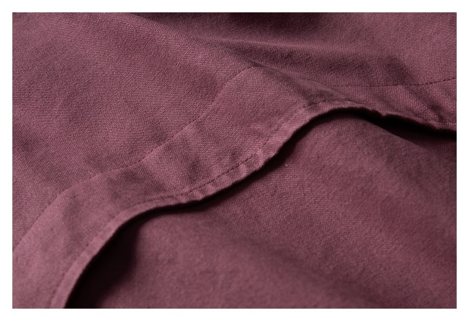 Close-up of mauve jacket fabric and a curved stitched seam.