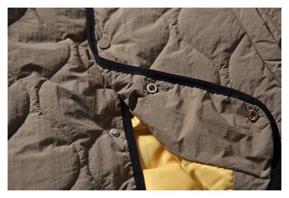 Close-up of the jacket opened to show snap fasteners, black binding, and a yellow inner lining.