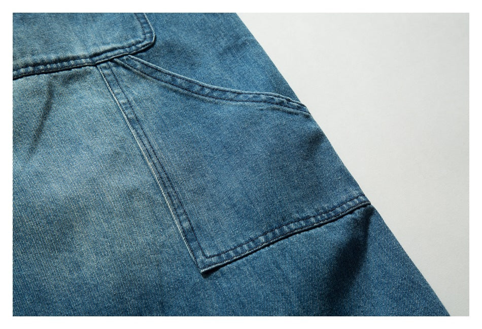 Close-up of blue denim with a stitched pocket corner and diagonal seam.