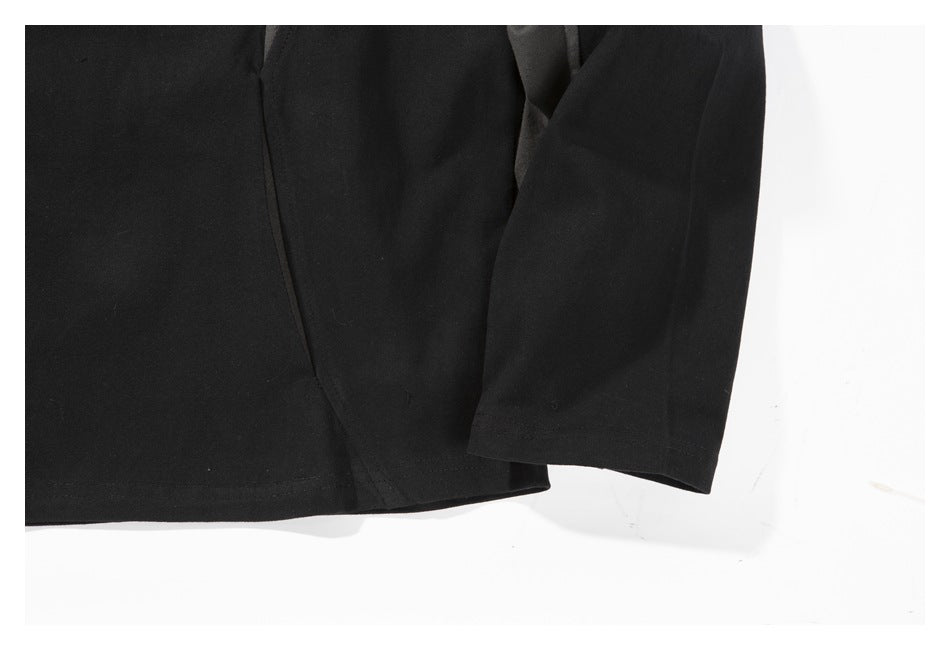 Close-up of the black shirt's lower hem and sleeve, showing the raglan panel seam.