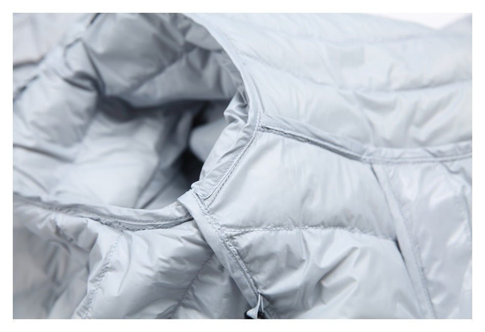 Close-up of a stitched pocket opening and quilted panels on the light gray jacket.