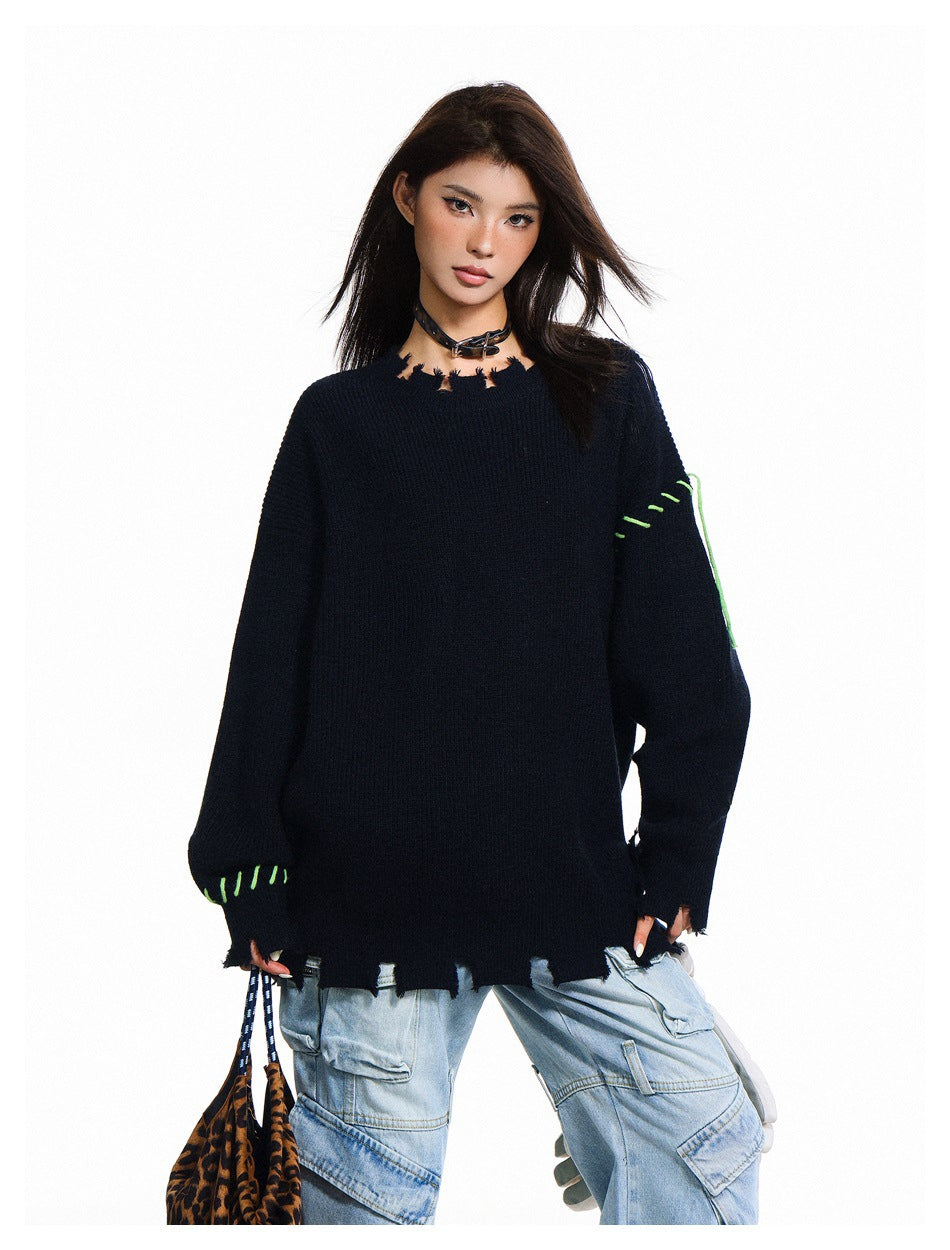 Closer view of a model wearing a dark navy oversized sweater with a distressed neckline and bright green contrast stitching.