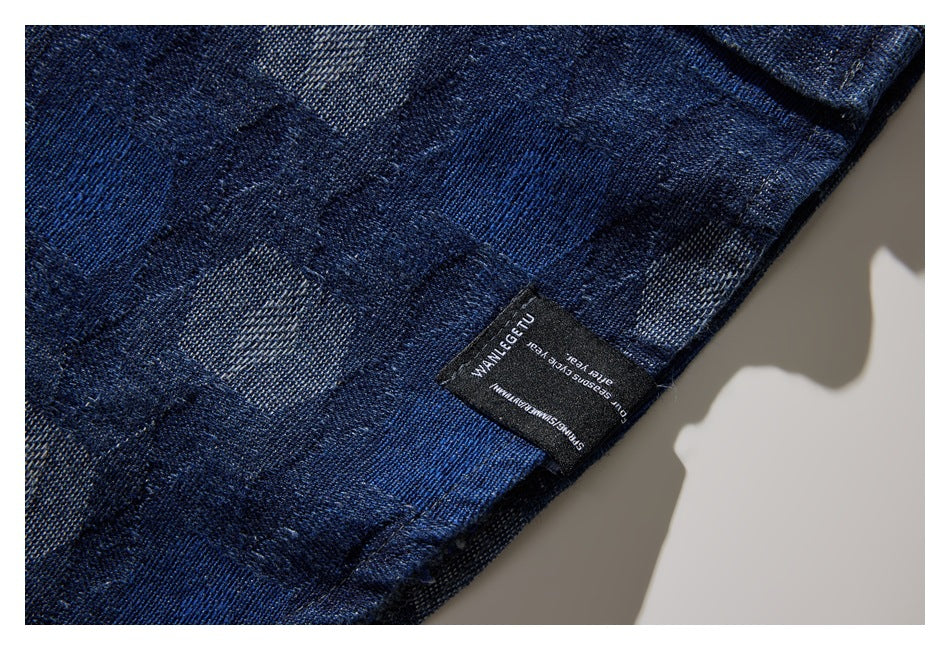 Close-up of dark blue patterned shirt fabric with a small black sewn label at the edge.