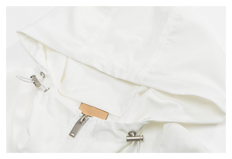Close-up of the white jacket's hood edge, zipper, and adjustable drawcord toggles.