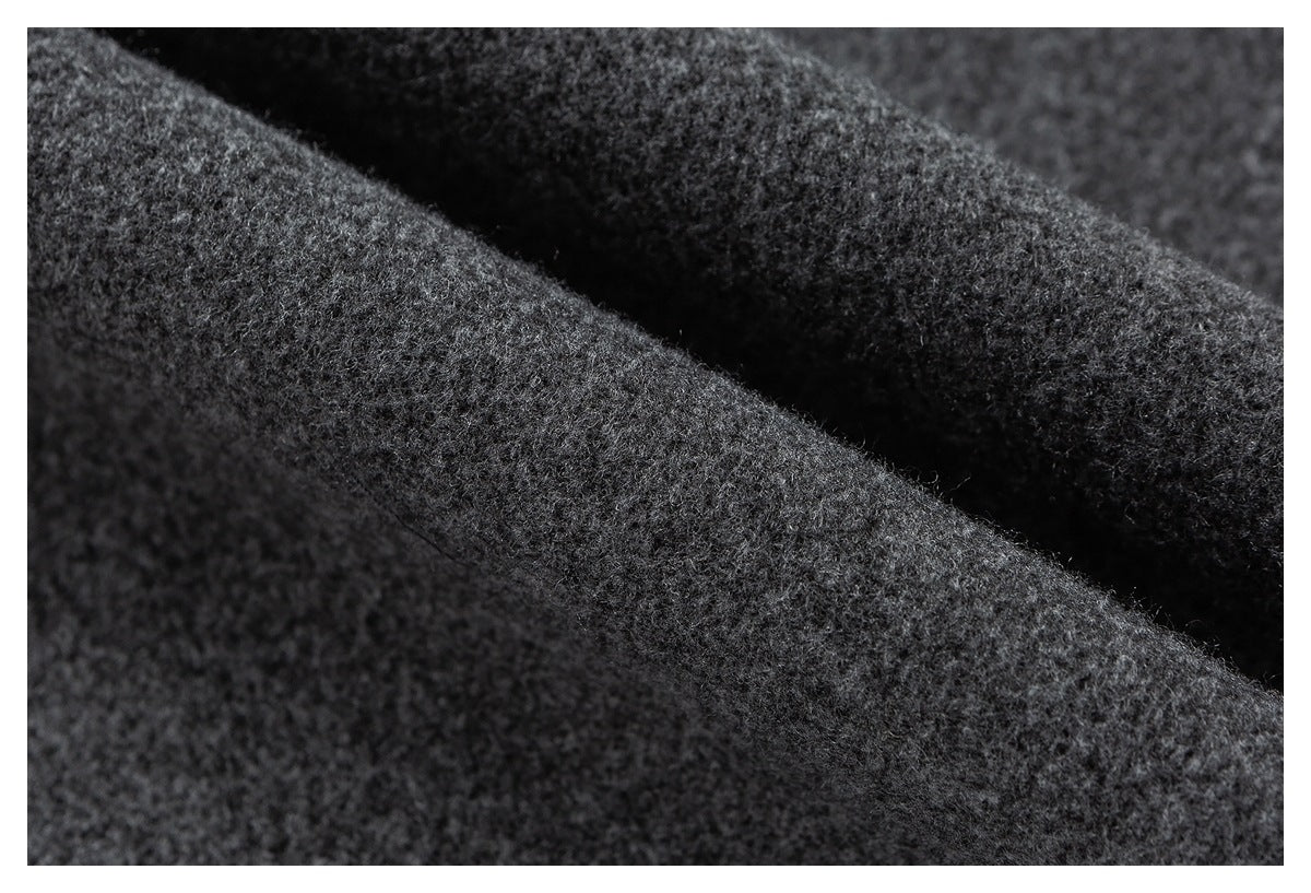 Extreme close-up of dark gray fabric with a soft, fuzzy surface and folded ridges.