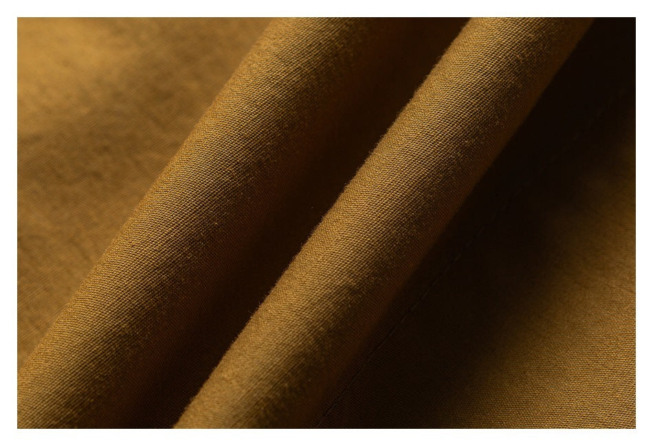 Macro view of the brown fabric’s fine woven texture and folded edge.