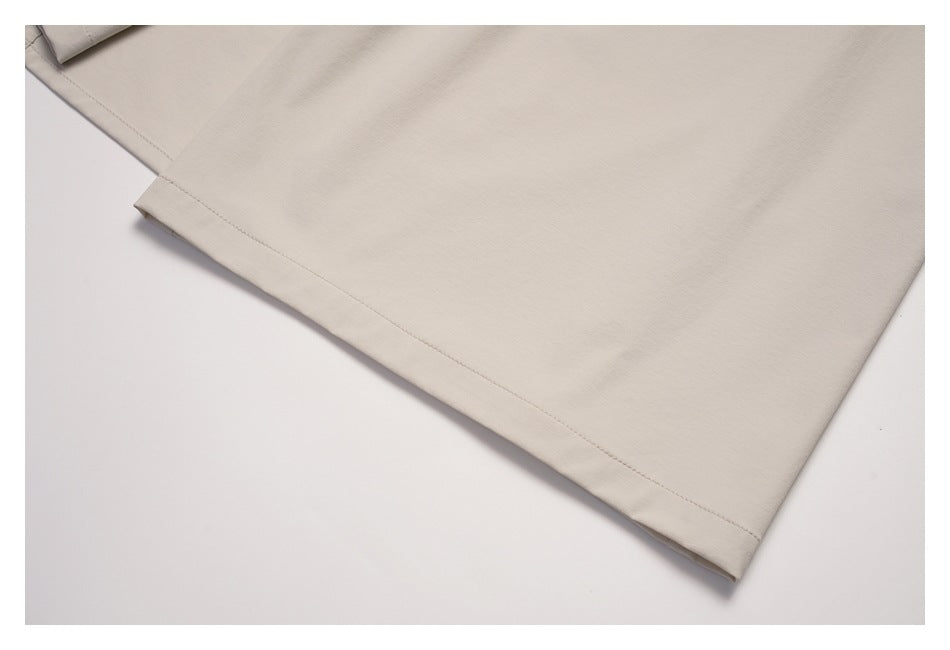 Close-up of the stitched hem on a light beige garment.
