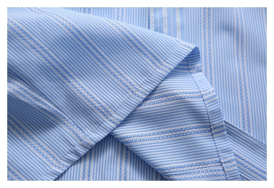 Close-up of folded striped shirt fabric showing a stitched edge and contrasting stripe directions.
