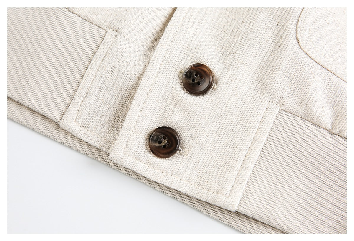 Close-up of two dark brown buttons on a cream jacket cuff.